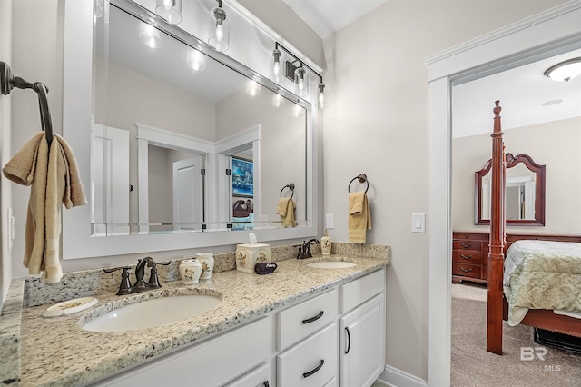 bathroom with double vanity, a sink, baseboards, and ensuite bath