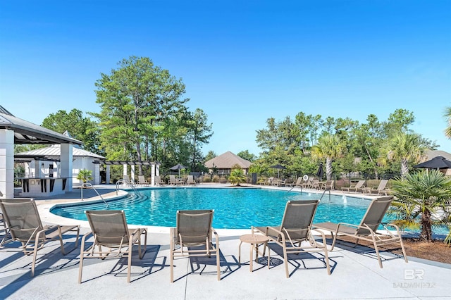 community pool with a patio and fence