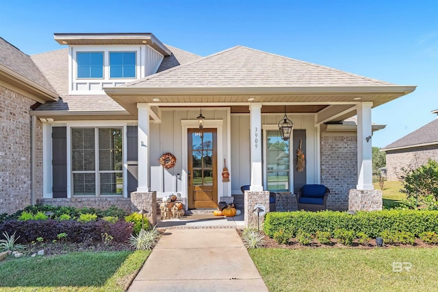 view of exterior entry featuring covered porch, board and batten siding, and a shingled roof