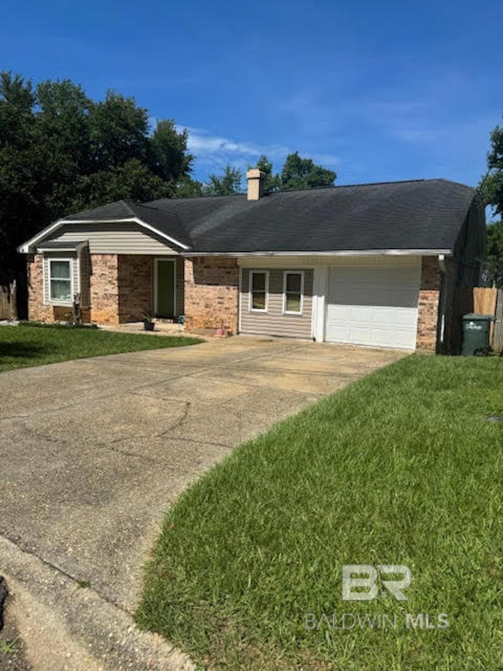 109 Eagle Dr, Daphne, AL 36526 - single story home with concrete driveway, a garage, a chimney, and a front lawn