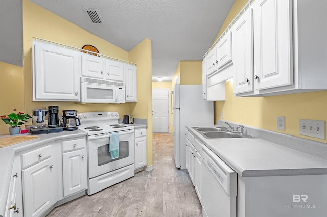 kitchen with white cabinetry, white appliances, sink, and light hardwood / wood-style flooring