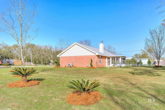 view of side of home featuring a yard, cooling unit, and a sunroom