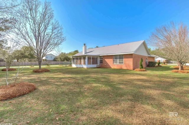 back of property featuring a yard and a sunroom