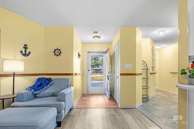 foyer entrance featuring light wood-type flooring and a textured ceiling