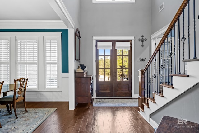 entrance foyer with dark wood-type flooring, visible vents, ornamental molding, french doors, and stairway