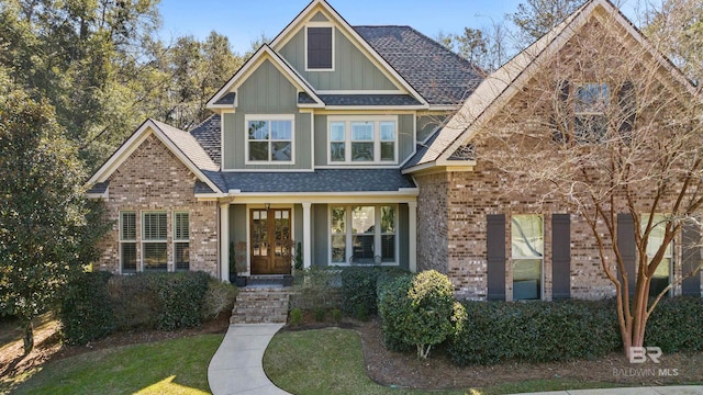 craftsman inspired home featuring board and batten siding, roof with shingles, french doors, and brick siding