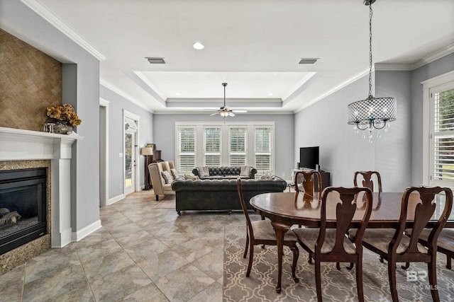 dining room featuring ornamental molding, a healthy amount of sunlight, visible vents, and a fireplace