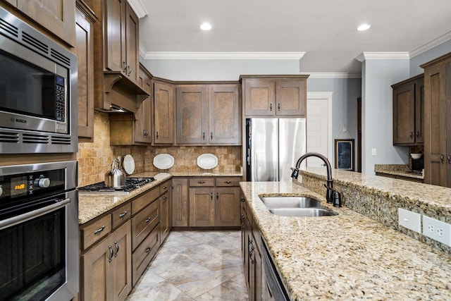 kitchen with light stone counters, stainless steel appliances, decorative backsplash, ornamental molding, and a sink