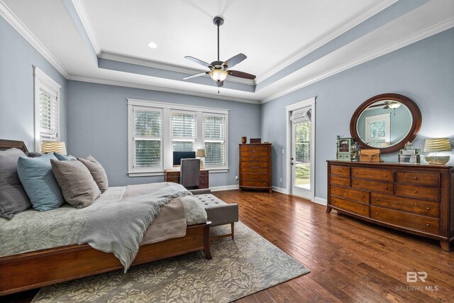 bedroom with dark wood-style floors, a tray ceiling, baseboards, and access to exterior