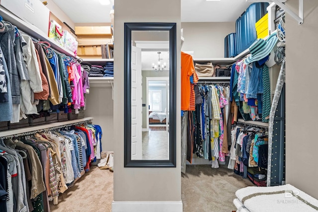 walk in closet with carpet floors and a chandelier