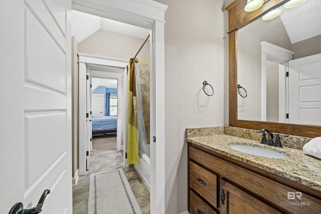 ensuite bathroom featuring shower / bath combination with curtain, vaulted ceiling, vanity, and ensuite bathroom