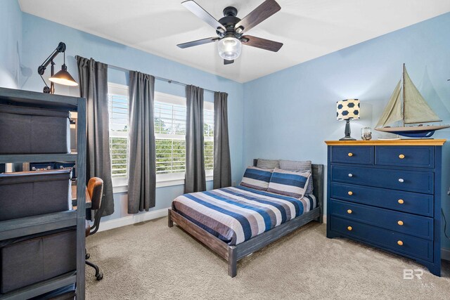 bedroom with ceiling fan, baseboards, and light colored carpet