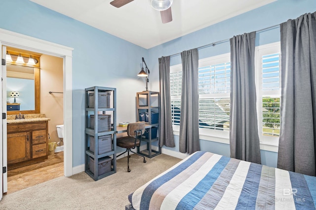 bedroom with light carpet, baseboards, a ceiling fan, connected bathroom, and a sink