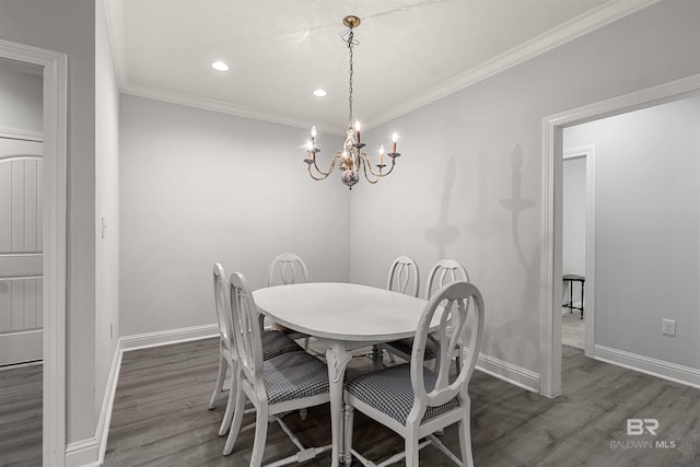 dining room with dark hardwood / wood-style floors, crown molding, and an inviting chandelier