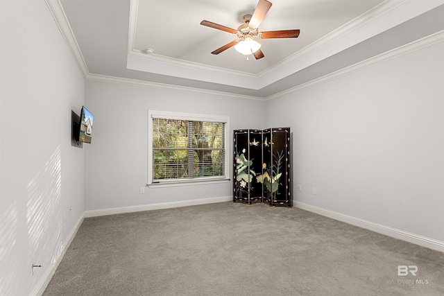 unfurnished room featuring ceiling fan, crown molding, light carpet, and a raised ceiling