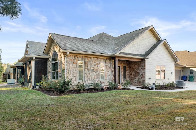 view of front of home with a front lawn and central AC