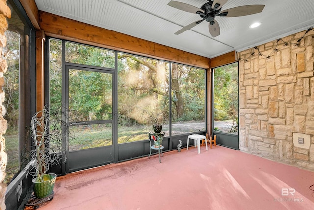 unfurnished sunroom featuring ceiling fan