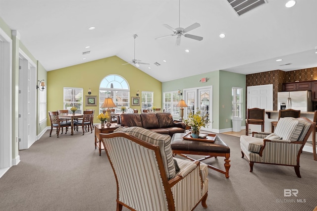 living room featuring ceiling fan, light colored carpet, and vaulted ceiling