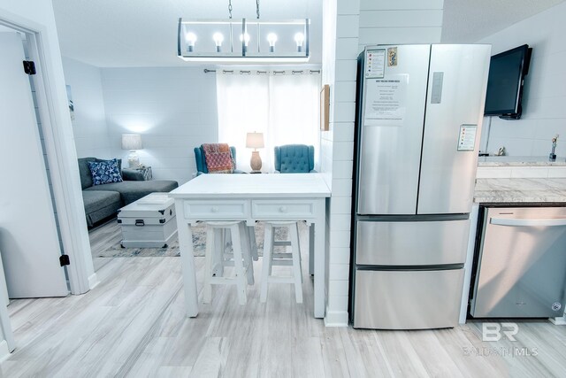 interior space featuring appliances with stainless steel finishes and wood finished floors