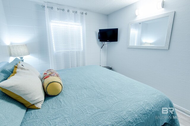 bedroom featuring a textured ceiling and wood finished floors