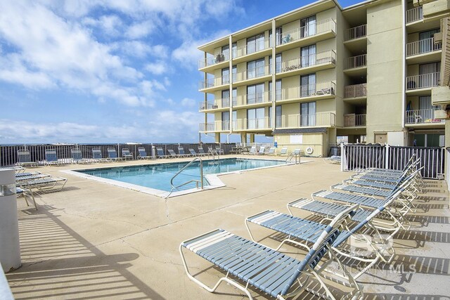 community pool featuring a patio area and fence