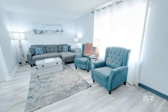 living area with light wood-type flooring and baseboards