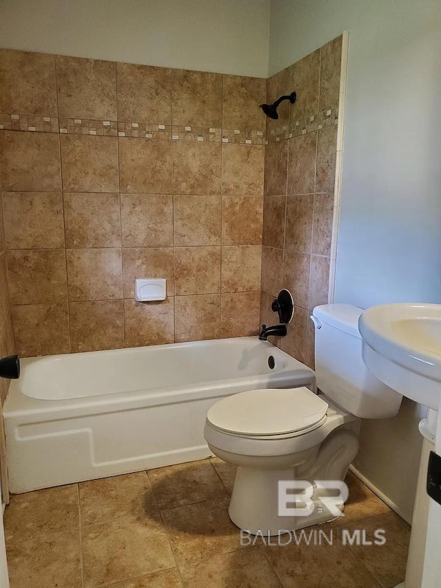 full bathroom with washtub / shower combination, toilet, and tile patterned flooring