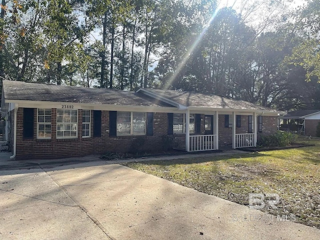 single story home featuring covered porch and brick siding