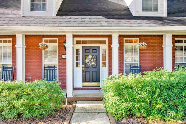 view of exterior entry featuring covered porch