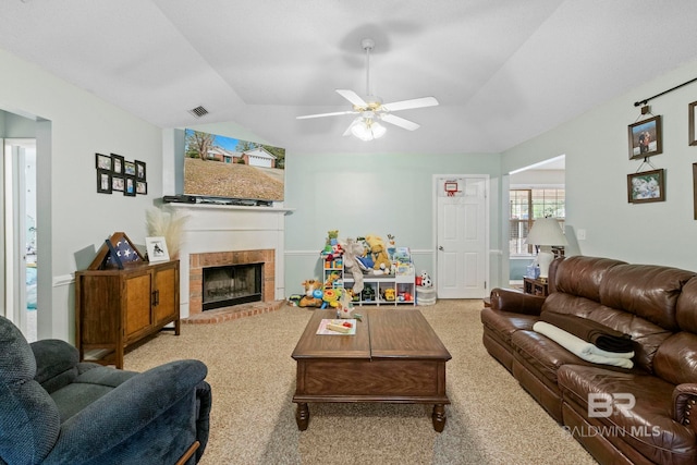 living room with vaulted ceiling, light colored carpet, a brick fireplace, and ceiling fan