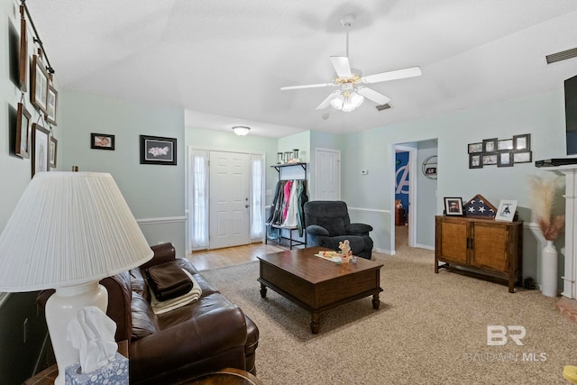 carpeted living room with ceiling fan