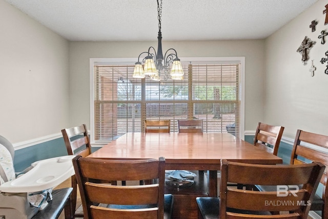 dining area with a chandelier and a textured ceiling