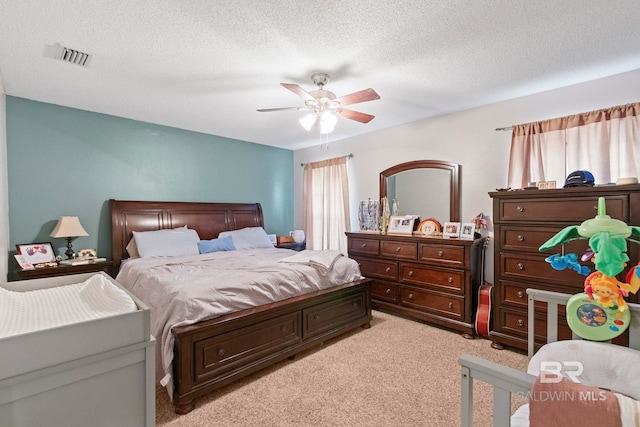 carpeted bedroom featuring a textured ceiling and ceiling fan