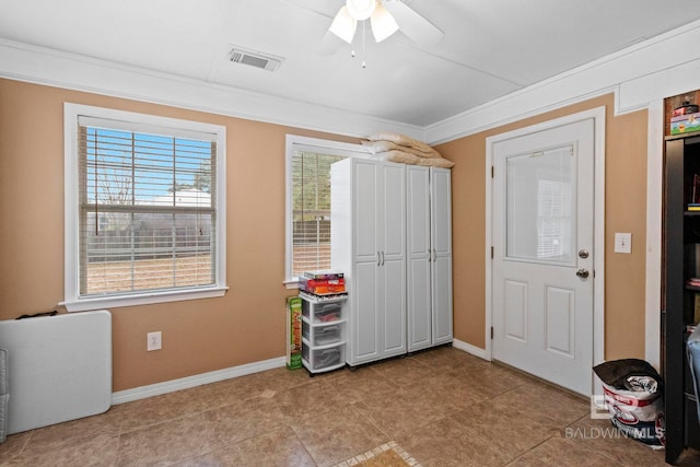 interior space with light tile patterned floors, ceiling fan, and crown molding