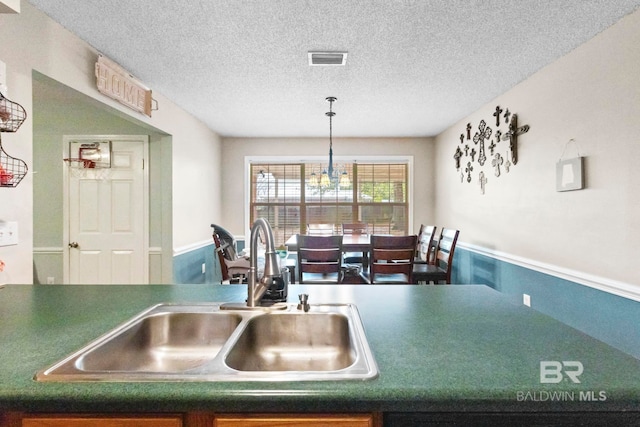 kitchen featuring a textured ceiling and sink