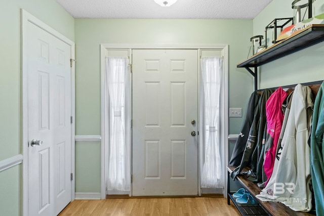 mudroom featuring a textured ceiling and light hardwood / wood-style flooring