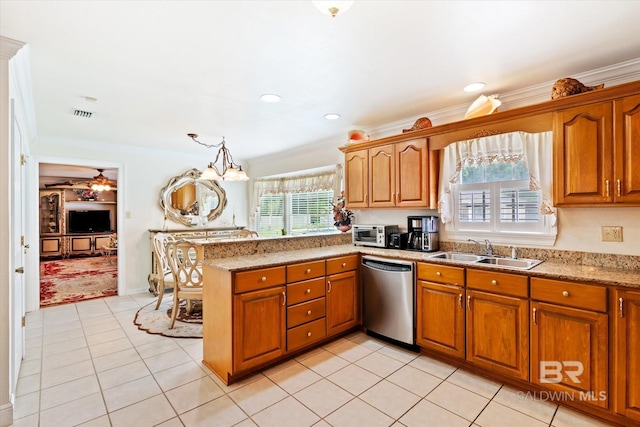 kitchen featuring an inviting chandelier, sink, stainless steel dishwasher, a wealth of natural light, and decorative light fixtures