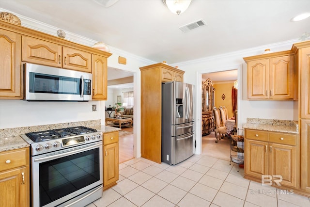 kitchen with stainless steel appliances, light stone counters, light brown cabinetry, light tile patterned floors, and ornamental molding