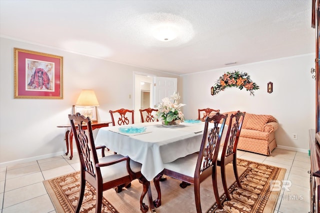 dining room featuring crown molding, light tile patterned flooring, and a textured ceiling