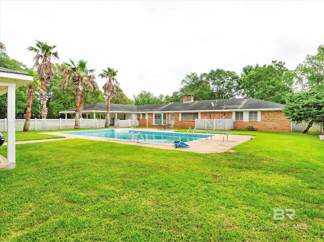 view of swimming pool with a lawn