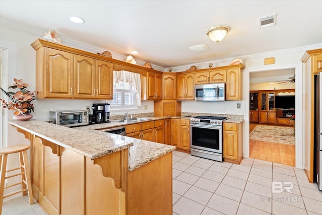 kitchen featuring light tile patterned floors, stainless steel appliances, ornamental molding, and sink