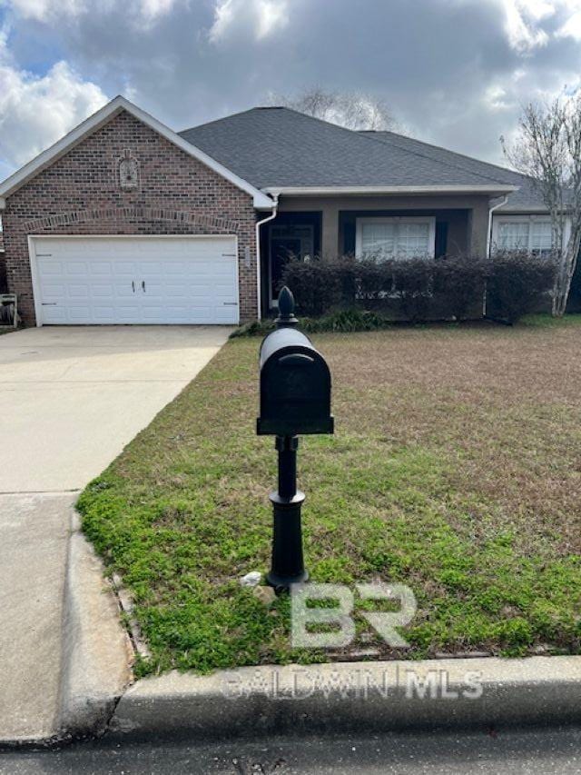 ranch-style home with a garage, a front yard, concrete driveway, and brick siding