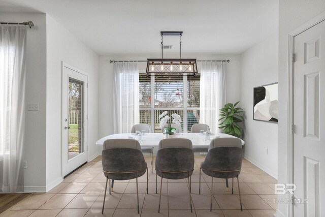 dining room featuring a wealth of natural light, baseboards, and light tile patterned floors