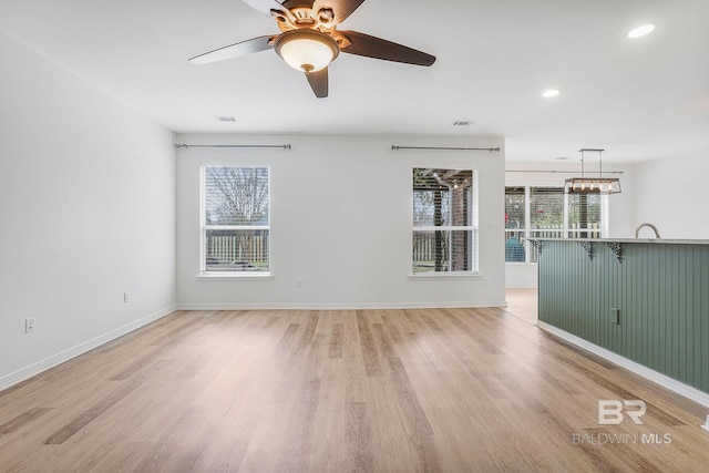 unfurnished living room featuring light wood-type flooring, visible vents, and baseboards