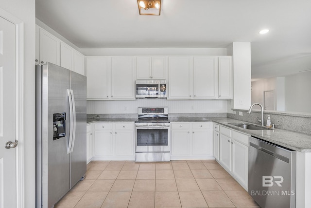 kitchen with stainless steel appliances, a sink, and white cabinetry