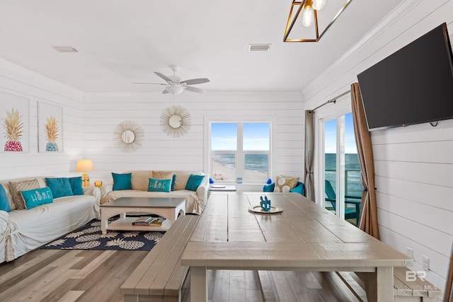 living room featuring a ceiling fan, wood finished floors, and visible vents