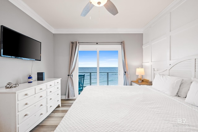 bedroom with access to exterior, light wood finished floors, crown molding, ceiling fan, and a water view