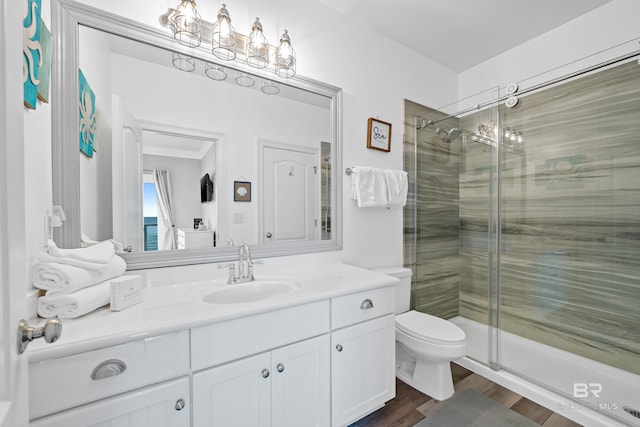 full bath with wood finished floors, toilet, a stall shower, and vanity