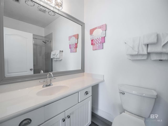 bathroom featuring visible vents, toilet, vanity, and walk in shower