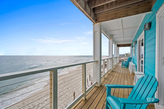 wooden deck with a view of the beach and a water view